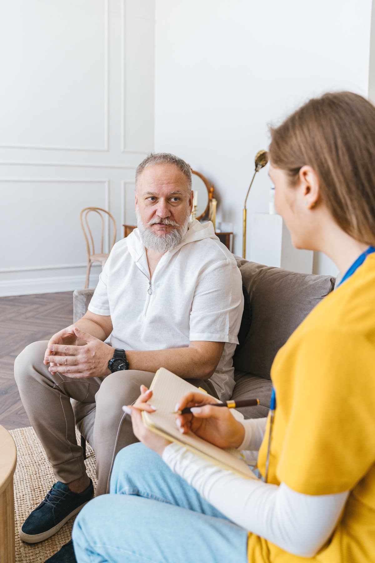Two adults having a focused conversation with one person listening attentively.