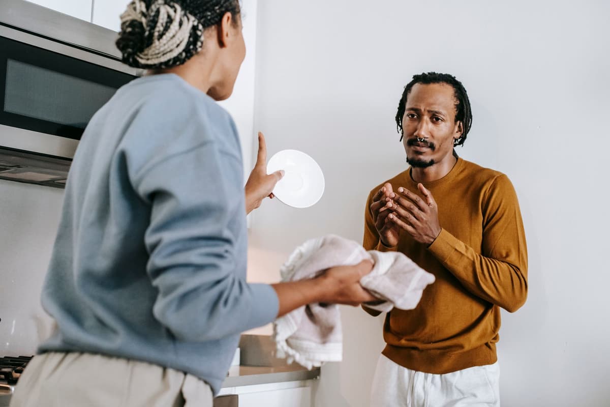 Two people having a tense conversation in a kitchen.