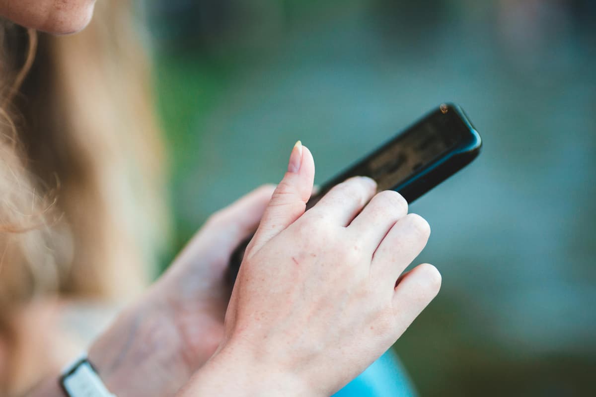 Close-up of a person using a smartphone with both hands.
