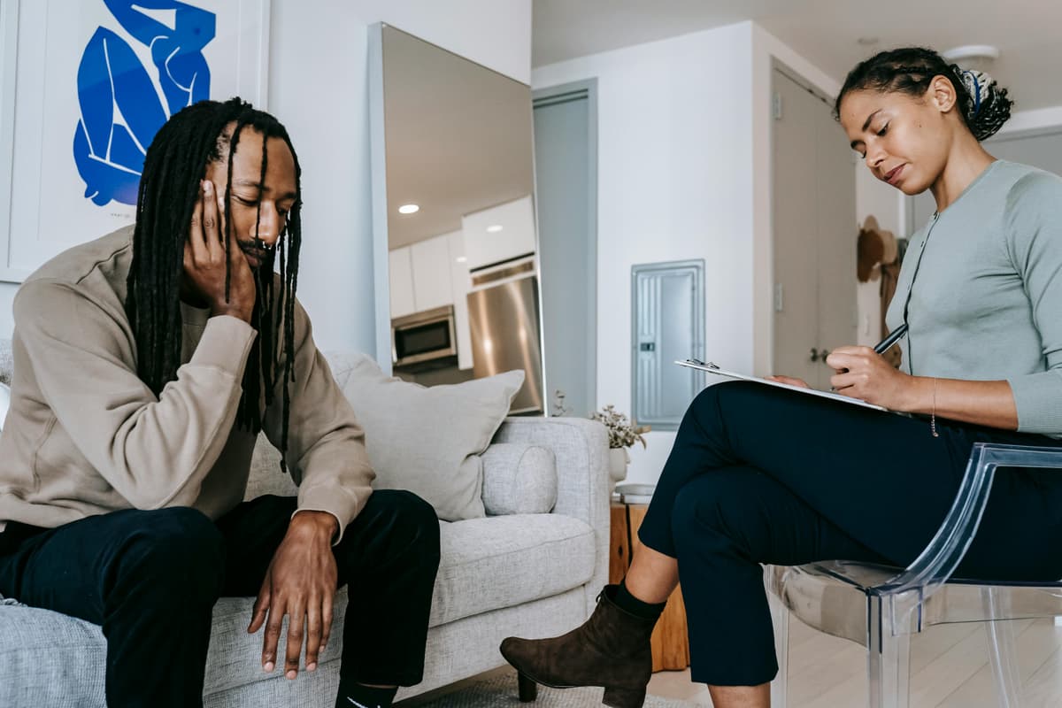 Two people talking face to face in a counseling session.