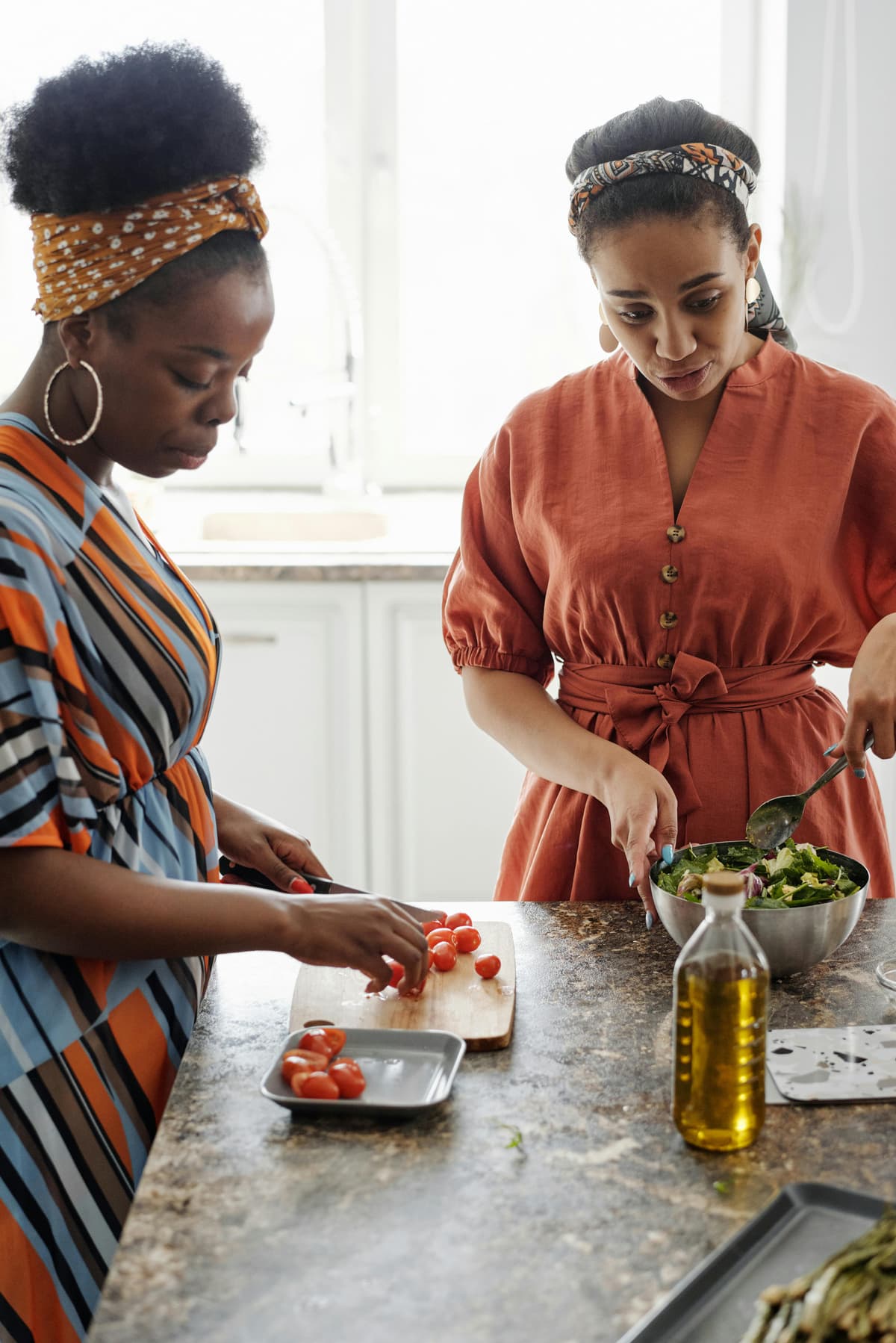 Two people preparing a salad together in a bright kitchen.