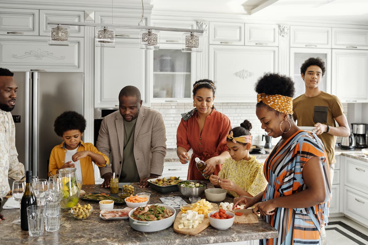 A family preparing food together around a kitchen island.