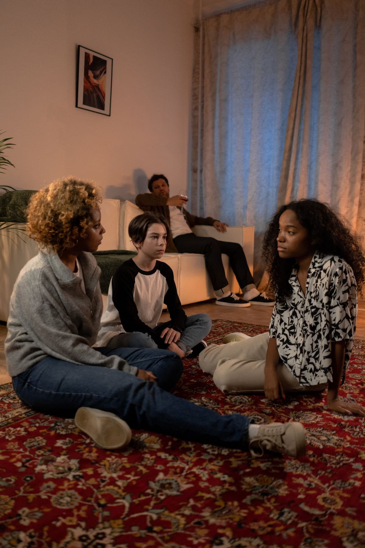 Family members seated together during a serious living-room conversation.