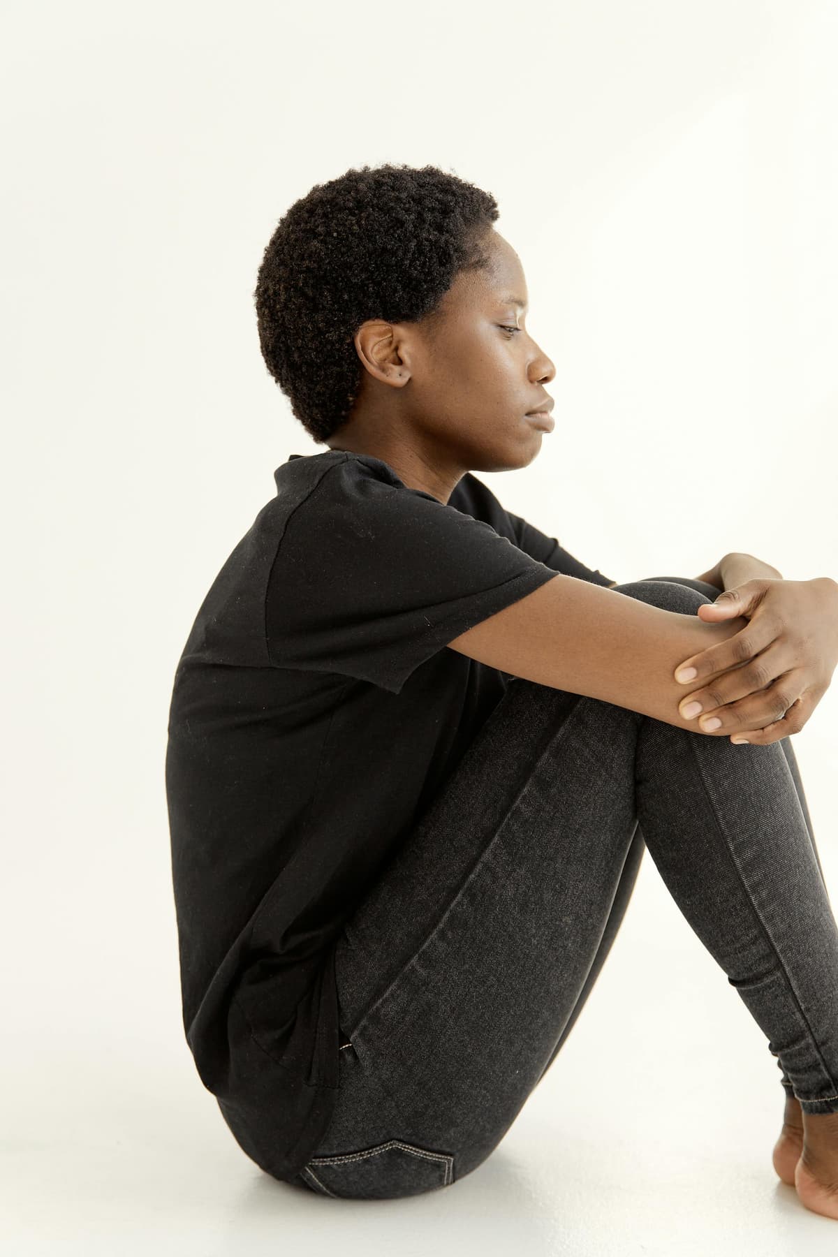 A person sitting curled up alone on the floor.