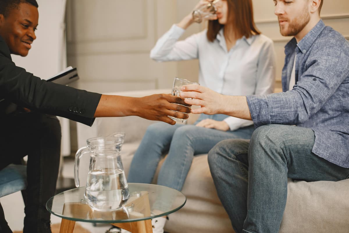 A facilitator offering a glass of water during a support session.