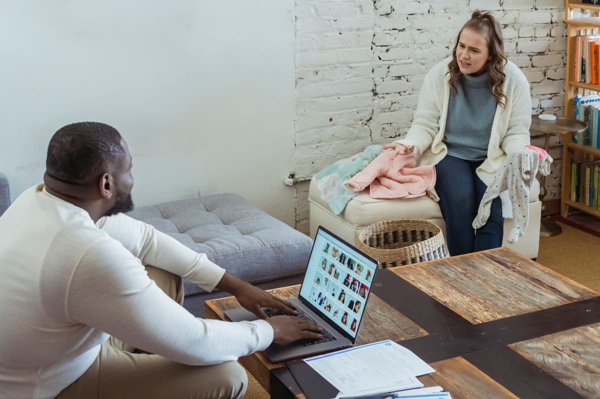 Two partners sitting apart during a serious conversation at home.
