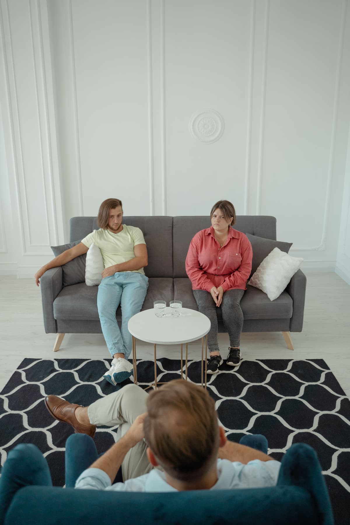A couple seated on a couch during a therapy session.